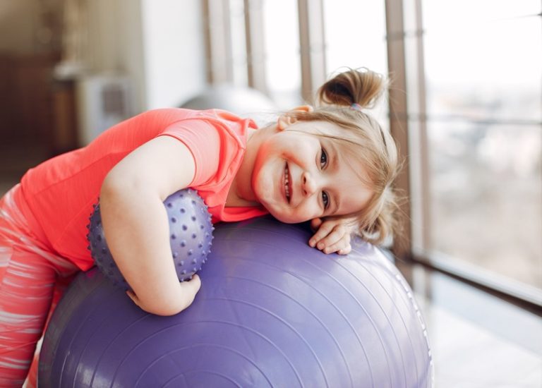Beautiful girl in the gym. Cute little child in a pink sportswear